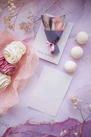 Delicate pink and white marshmallow with decoration of gypsophila and dryflowers bouquet. Mock up card. Feminine background, template. Cozy winter weekends. Homemade sweets. High quality photoの写真素材