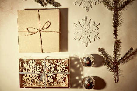 Festive vintage retro card with present box, crafting decoration, branch of fir tree and shadows. Modern DIY style. Merry Christmas concept close up. High quality photoの写真素材