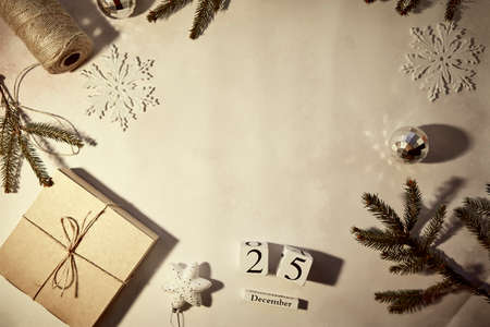 DIY handmade Christmas present. Retro vintage card with crafting decoration, string, branches of fir tree, gift box and trendy ornaments with shadows. Merry Christmas concept. Vignetting, copy space.の写真素材