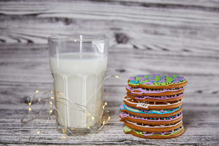Cute Christmas tradition. Handmade fresh cookies and warm glass of milk on the wooden table. Table...