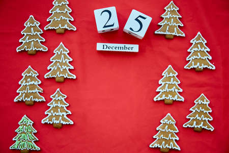 Christmas homemade gingerbread cookies with copy space and date of Christmas on red fabric background. Copy space. Festive aesthetic card. Christmas atmosphere. High quality photoの写真素材