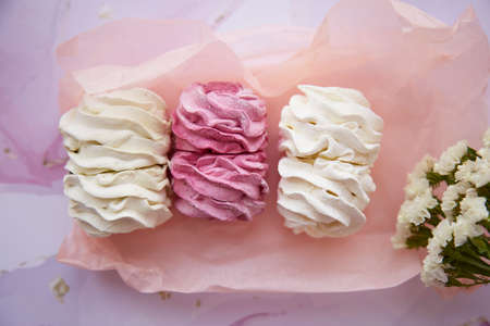 Tender pink and white marshmallow with decoration of dryflowers. Feminine card concept. Cozy winter weekends. Homemade sweets. Top view. High quality photoの写真素材