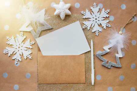 Beige, crafting stationery card, envelope mock up, pen. Trendy Christmas decorations on basic background. Aesthetic festive atmosphere. Greeting card sending concept. View from above. Place for textの写真素材