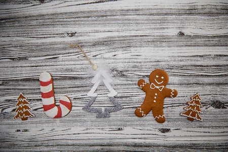 Different colorful handmade Christmas cookies and festive ornaments on the vintage wooden table...