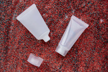 Mock up white container for cosmetic product on bright sand background. Creative mockup of beauty...