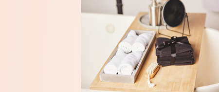 Bathtub with wooden shelf for spa procedure. Towels. brush, mirror. Cozy home concept. Extra wide banner. Copy space. High quality photoの写真素材