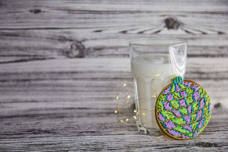 Milk with cookie for Santa. Handmade fresh cookies and glass with milk on the vintage wooden table....