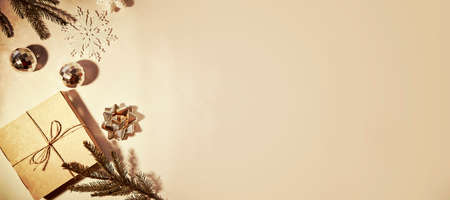 Retro vintage card background with aesthetic crafting Christmas decorations: branches of fir tree, gift box and trendy disco balls with shadows. Merry Christmas concept. Extra wide banner.の写真素材