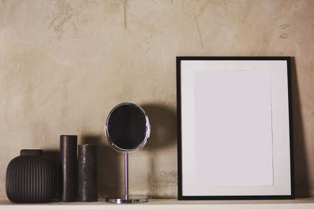 Wall picture frame mock up for design or text. Candles, vase and mirror. Cozy bedroom. Modern interior, copy space.の写真素材