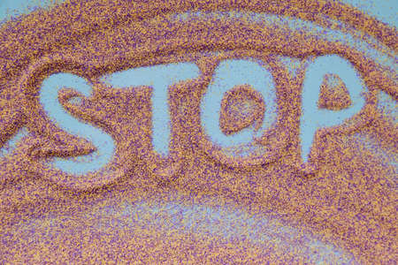 Stop handwritten text on colorful sand. Close up. High quality photoの写真素材