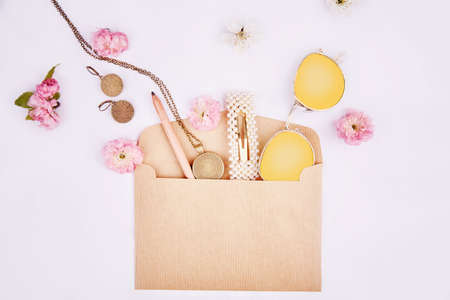 Splash of women accessories from envelope with pink flowers. Sunglasses, accessories, hairpin,...