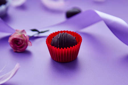 Chocolate candy. Trendy pink feathers, pink rose and purple ribbon. Very peri pantone color patternの写真素材