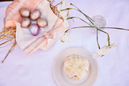 Easter background. Very peri and orange multicolored eggs, Easter cake and narcissus flowers. easter...