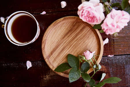 Menu or recipe mockup wooden plate, podium. Morning aesthetic. Invitation, wedding, Mothers day card mockup among pink tea rose petals. Place for text. View from above.の写真素材