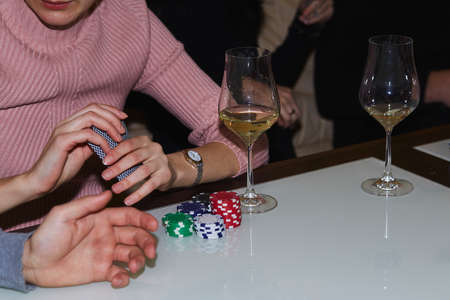 Woman holding cards in poker game. Cards, dices and glass of champagne. candid moment. Poker...