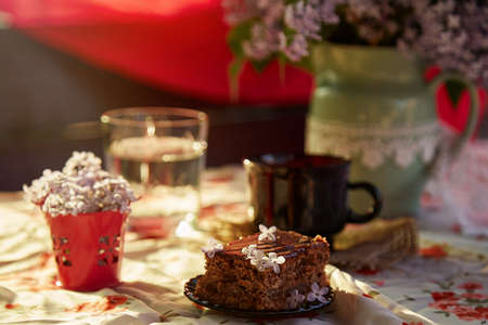 Homemade chocolate cake brownie. Dessert and cup of coffee among flowers. Atmospheric breakfast.の写真素材