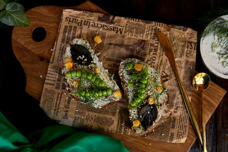 Homemade natural healthy sandwich with peas, basil, corn on greased cheese. Healthy natural food with cutleryの写真素材