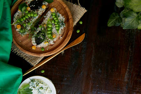 Homemade natural healthy sandwich with peas, basil, corn on greased cheese. Healthy natural food under natural hard shadows. copy spaceの写真素材