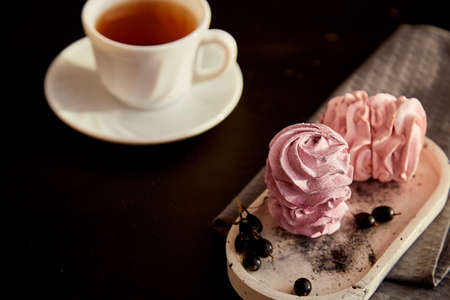 Aesthetic dessert - berry marshmallows with currant and cup of black tea. Autumn cozy atmospheric...