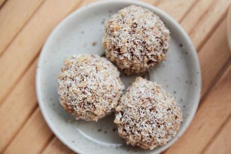 Vegan handmade gluten and sugar free delight - natural sweets balls on the wooden table close up....