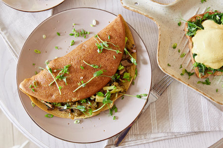 Vegan pancakes filled with mushrooms, pea sprouts, avocado. Eggs benedict with plant-based sauce,...