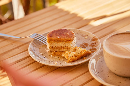 Aesthetic gluten free no baking carrot cake under hard shadows with cup of cappuccinoの写真素材