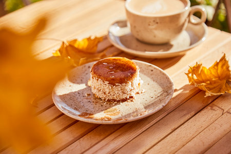 Aesthetic autumn healthy carrot dessert with agave syrup. Cake with cup of coffee under hard shadows outside. Healthy breakfast.の写真素材