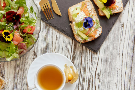 Healthy pescetarian breakfast - toasts and fresh salad. Appetizer with salmon, cottage cheese,...