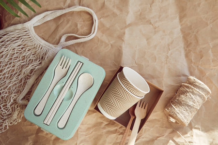 Sustainable tableware cutlery, cardboard cups made from natural materials and reusable bag on crumpled paper. Zero waste, eco-friendly lifestyle.の写真素材