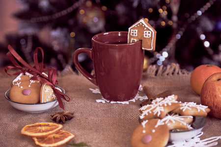 Aesthetic cozy winter desserts. Ginger cookies of cute homes, snowflakes and cup of coffee. Cozy warm home background.の写真素材