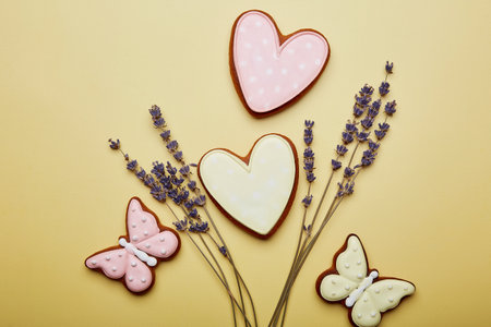 Pastel spring cookies and lavender. Women's Day, Mother's Day. Spring card with baked glazed cookies on yellow background. Feminine background.の写真素材