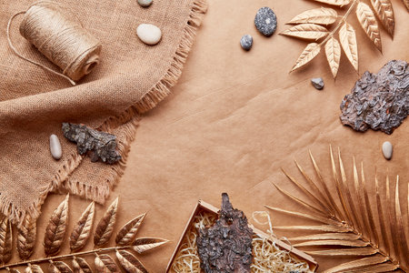 Natural brown eco-friendly, sustainable background with copy space. Natural Cotton Thread, tree bark, golden leaves, pebbles on crafting paper.の写真素材