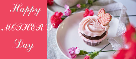 Happy Mothers Day extra wide banner and aesthetic cupcake with pink flowers.の写真素材