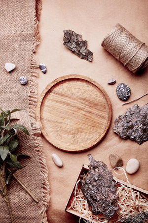 Sustainable, eco-friendly lifestyle. Natural wooden mock up - template tray among tree bark, green leaves, pebbles, cotton thread.の写真素材