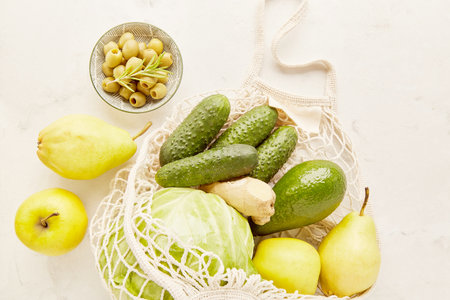 Fresh shopping groceries in reusable bag. Olives, cucumbers, cabbage, pears. Zero waste, sustainable...