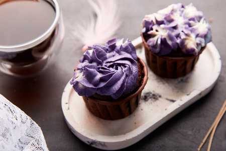 Purple aesthetics trendy floral cupcake and cup of coffee. French no sugar dessert close up.の写真素材