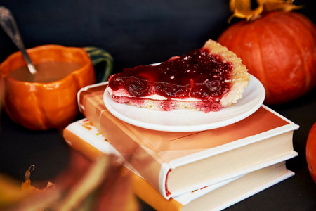 Aesthetics cozy home - autumn cup of coffee in shape of pumpkin, cherry pie and books. Atmospheric cozy coffee time.の写真素材