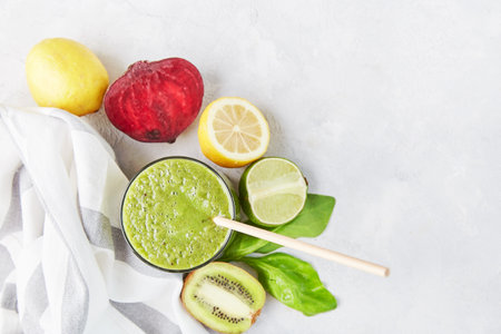 Green healthy smoothie with kiwi, lemon, spinach and betroot. Vegan, KETO, plant-based diet flat lay. copyspace.の写真素材