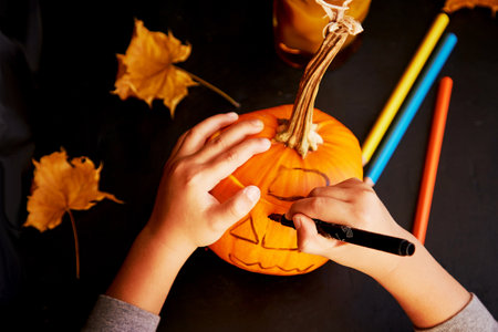 Child drawing a pumpkin of Jack o lantern for Halloween. Handmade decorations for holidays. children creativity.の写真素材