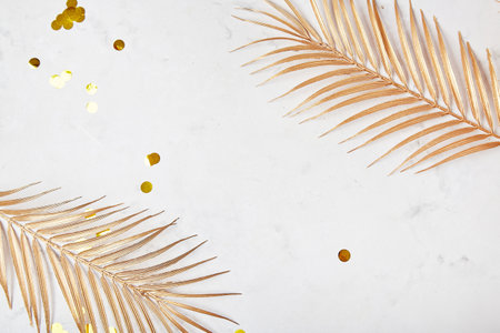 Minimalist background with golden artificial palm leaves with copy space. Place for New Years ideas, resolutions, goals.の写真素材