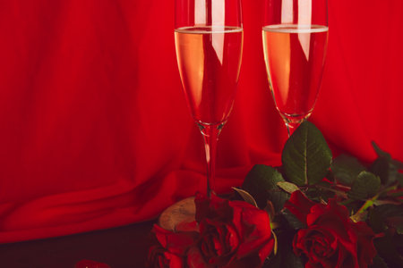 Traditional Valentines day background. Red roses, champagne glass - seasonal romantic dinner with copy space.の写真素材