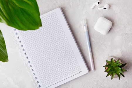 Creative Workspace Elegance: Open Notebook, earphones, pen and Flat Lay.