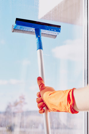 Spring cleaning concept. Man is washing windows on sunny day. Household chores. Disinfection during...
