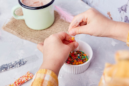 Enjoying the taste of Easter traditions as a child sprinkles cookies for a festive vibe.