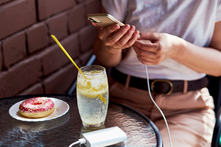 Freelance flexibility a woman charges her phone with a powerbank while working remotely.の写真素材