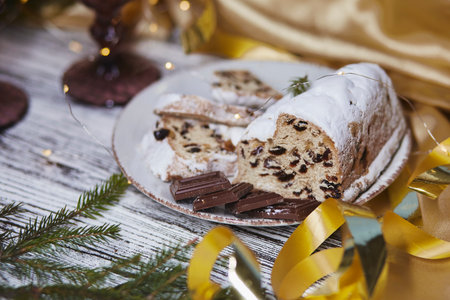 Atmospheric Christmas stollen and chocolate close up. Holidays decorations. Aesthetic traditions background. Table setting.の写真素材
