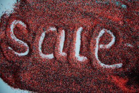 Sale hand written discount concept on sand surface. Colorful sand. Creative sales concept. Top view.の写真素材