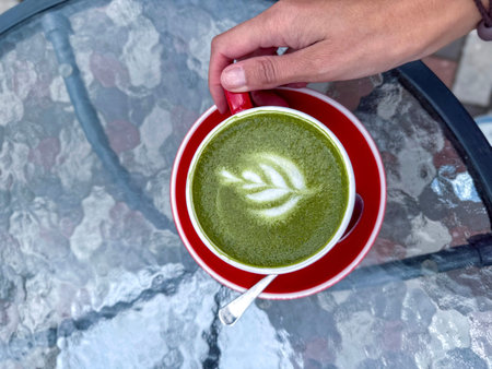 Top view of matcha in red cup. Slow living, self-care, wellness, peaceful mornings and natural energy boost, health, tea culture and everyday rituals.の写真素材
