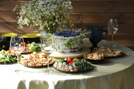 Floral decorated cake and starters in natural light setting.