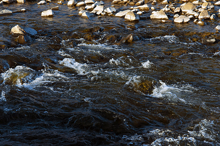 Close-up of water bubbling among the rocksの写真素材